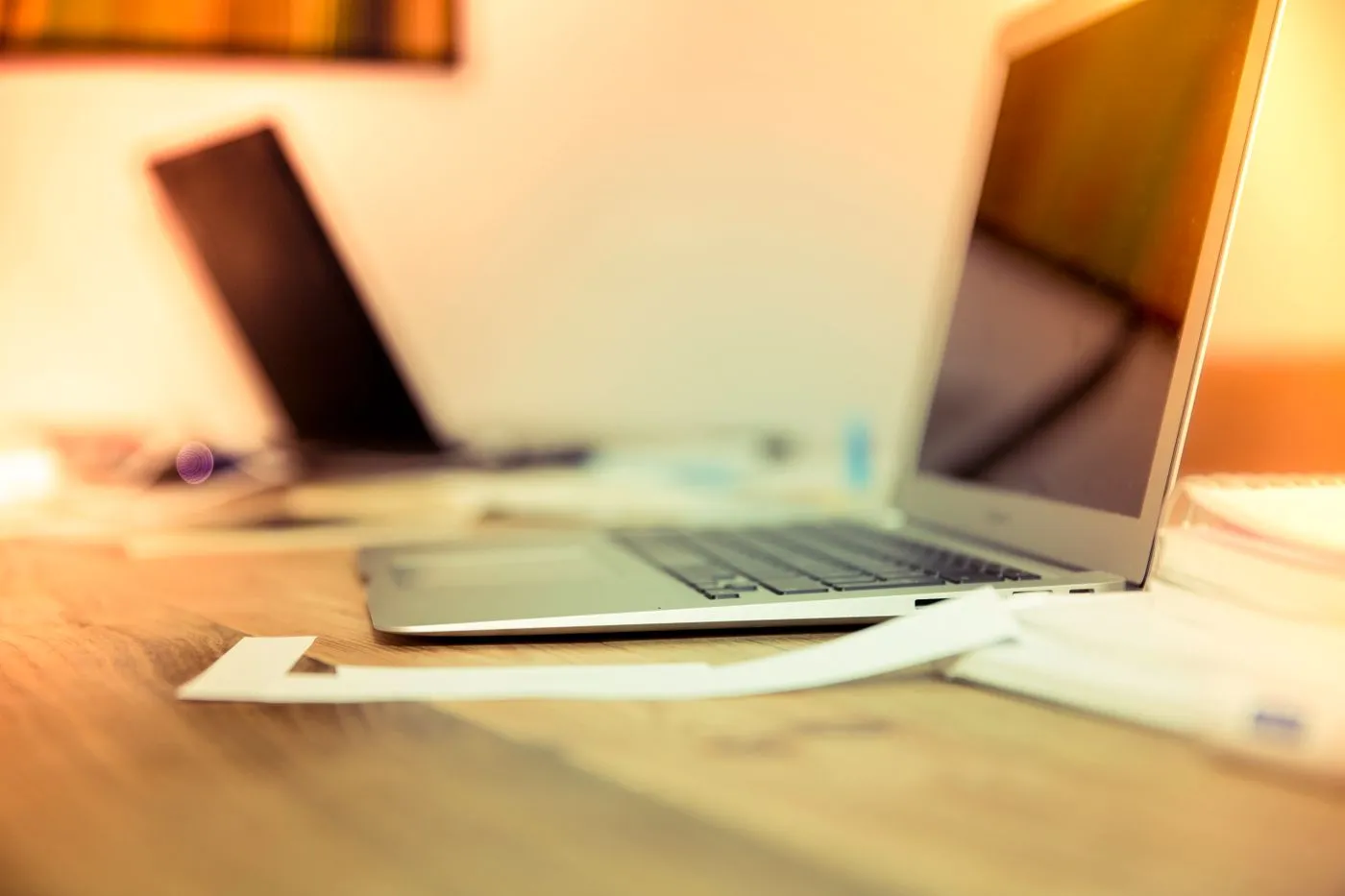 Two laptops on a warm-lit creative desk