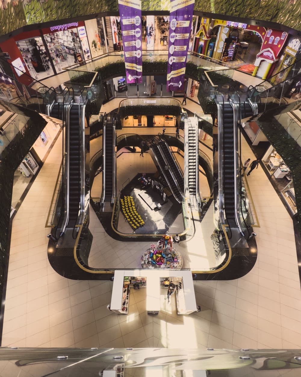 Busy shopping mall with escalators and storefronts