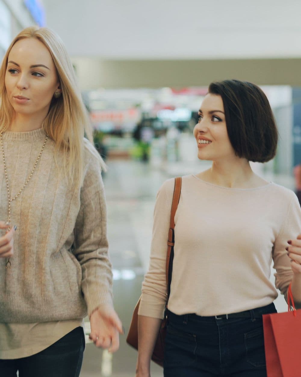 Shoppers walking through a mall with shopping bags
